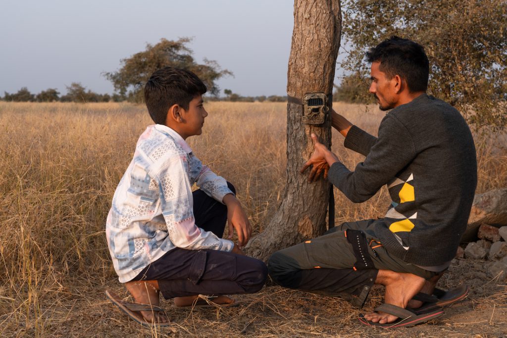 Pankaj Bishnoi, Community Engagement Officer of BNHS from Khetolai teaches camera trapping to his nephew Divyansh Bishnoi. Image by: Akshita Jain.